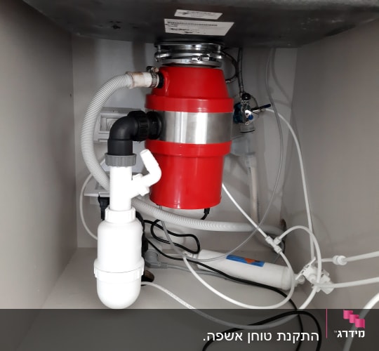 מערכת צינורות מתחת לכיור עם טוחן אשפה אדום